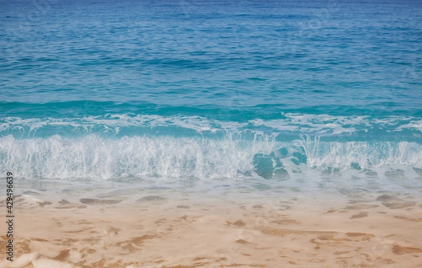 Obraz Closeup shoot of calm sea waves and foam on the sand beach.