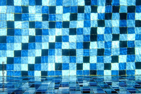 Fototapeta Top view of swimming pool tiled floor with the side wall through crystal clear water