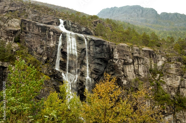 Obraz waterfall with dark mountain wall in norwegian landscape