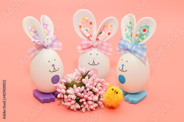 Obraz Artificial eggs rabbits, on a pink background with a yellow chicken, art staging