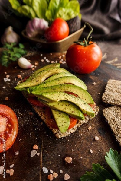 Obraz Wholemeal bread with tomato slices and avocado