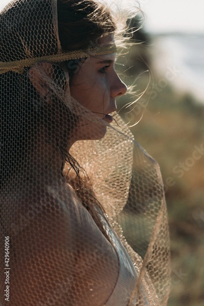 Obraz Close-up A beautiful girl in a stilted suit sits on a mountain above the sea, a lake on a sunny day.