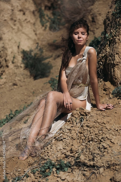 Obraz Close-up A beautiful girl in a stilted suit stands on a mountain above the sea, a lake on a sunny day.