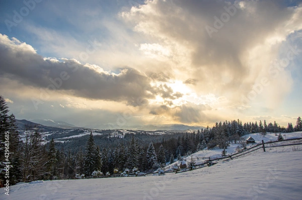 Fototapeta Panorama of a village in winter in the mountains at sunset