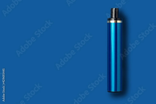 Fototapeta Disposable e-cigarette on blue isolated background. The concept of modern smoking, vaping and nicotine. Top view