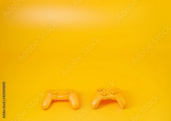 Obraz Two gamepads on a yellow table 