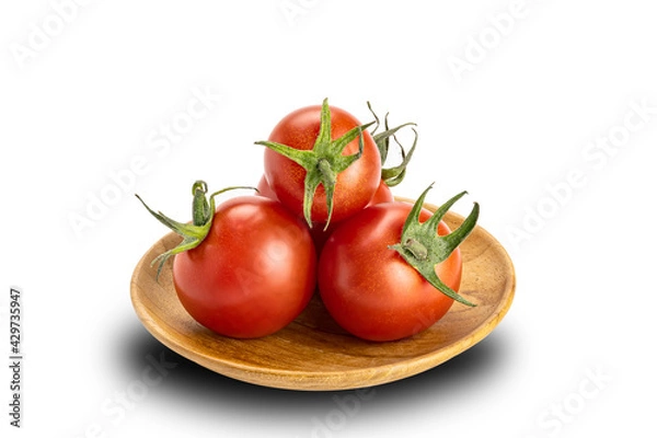Fototapeta Pile of ripe cherry tomatoes in wooden plate on white background. Tomatoes or Solanum lycopersicum or lycopersicon esculentum are source of the antioxidant lycopene which reduced risk of heart disease