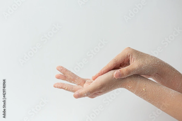 Obraz Young woman applying natural lemon scrub on hands against white background