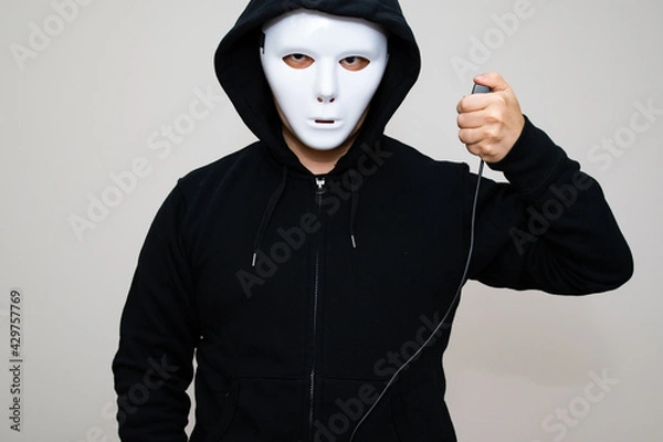 Obraz Hacker with anonymous mask holding a triggering device
