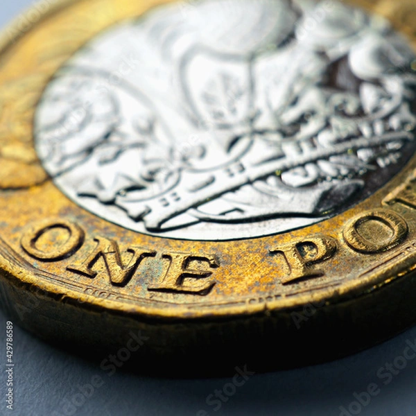 Fototapeta 1 one British pound coin. Focus is on denomination of coin and name of currency of UK. Dramatic square illustration with increased contrast and saturation about money and economy of Britain. Macro