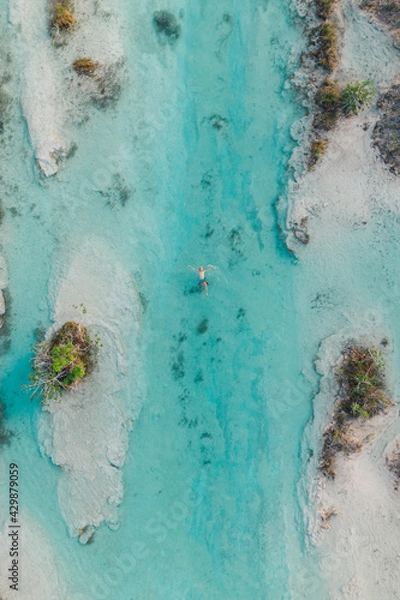 Fototapeta People swimming in sunny seven colored lagoon surrounded by tropical plants in Bacalar, Quintana Roo, Mexico
