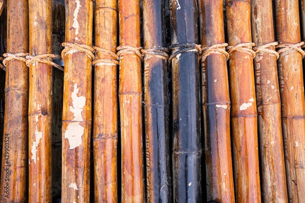 Fototapeta Bamboo rafting by a picturesque river in tropical jungles,yellow bamboo tied into the raft floating on the river,