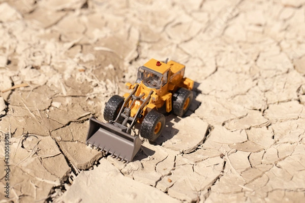 Fototapeta 渇水でひび割れた地面とホイールローダー