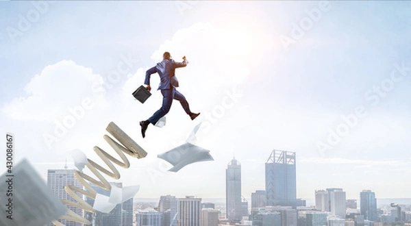 Fototapeta Businessman jumping on springboard . Mixed media