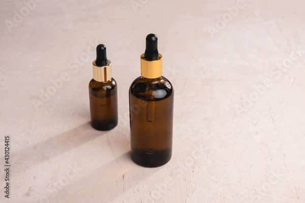 Fototapeta Eco Mineral oil in Amber glass bottles with pipette. Transparent hyaluronic serum gel and skin care concept. Top horizontal view copyspace of dropper glass.