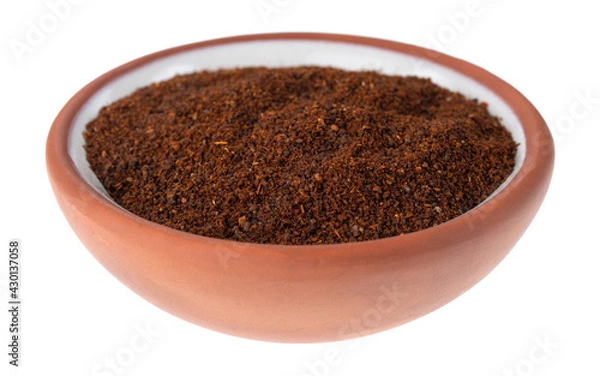 Fototapeta Side view of a small terracotta spice bowl filled with chili powder isolated on a white background.