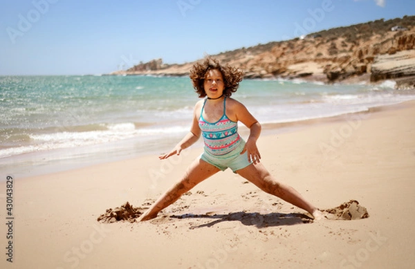 Fototapeta Girl is engaged in sports on the coast.