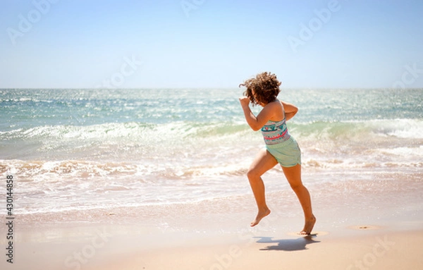Fototapeta Girl running on the beach.