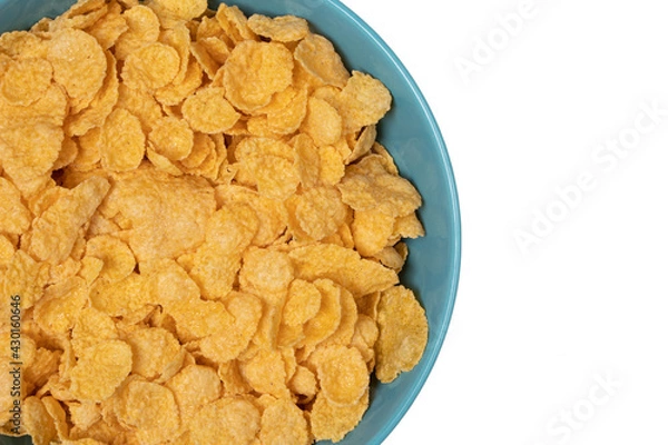 Fototapeta Cornflakes in a blue cup. Close-up. View from above. Isolated on white background. Copy space.