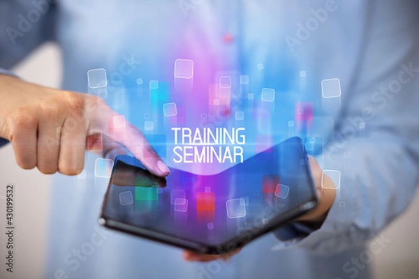 Fototapeta Young man holding a foldable smartphone