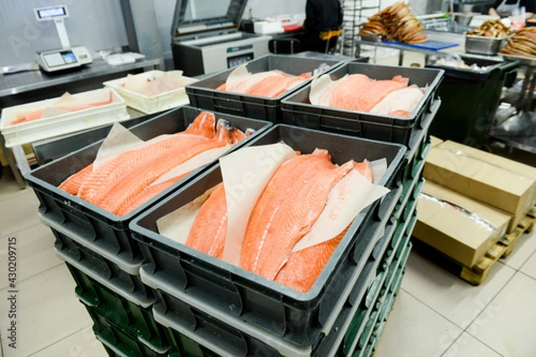 Fototapeta Plastic containers with red fish fillets lined with paper, close-up.