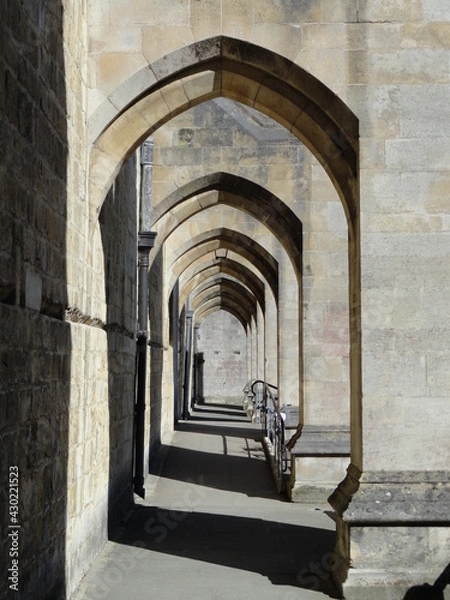 Fototapeta Corridor under the arches of a church. Old stone walls and architecture.