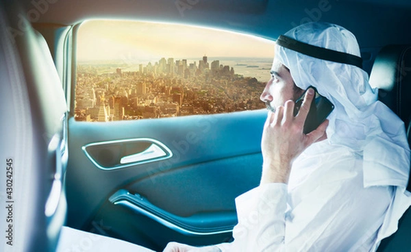 Obraz Sheik on the phone in the limo looks out the window.