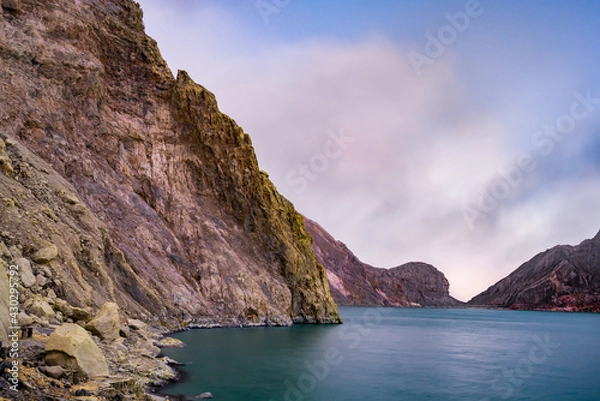 Fototapeta Ijen volcano crater and sulphur mining. Beautiful Landscape mountain and green lake with smoke sulfur in the morning in a Kawah Ijen volcano. Beautiful landmark from East Java, Indonesia