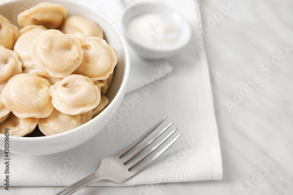 Fototapeta Bowl with tasty dumplings on light background