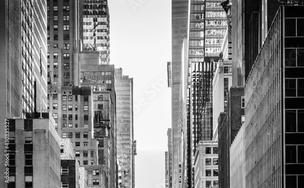 Fototapeta NYC buildings structure. Street view in Midtown Manhattan.  Close up New York architecture. Black and white wallpaper photo.