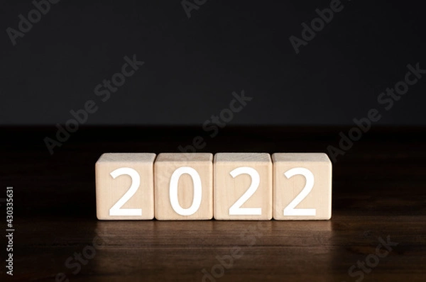 Fototapeta Wooden cubes on the table. New year 2022. Figures.