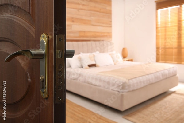 Fototapeta Wooden door open into modern hotel room, closeup