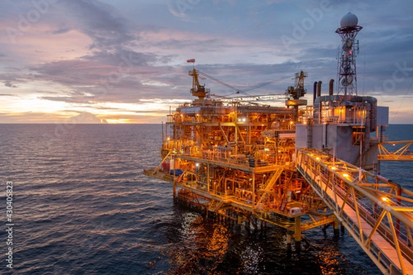Fototapeta Offshore oil and gas central processing platform in sun set which produce raw gas, crude and hydrocarbon then sent to onshore refine, petrochemical industry. Power and energy business.