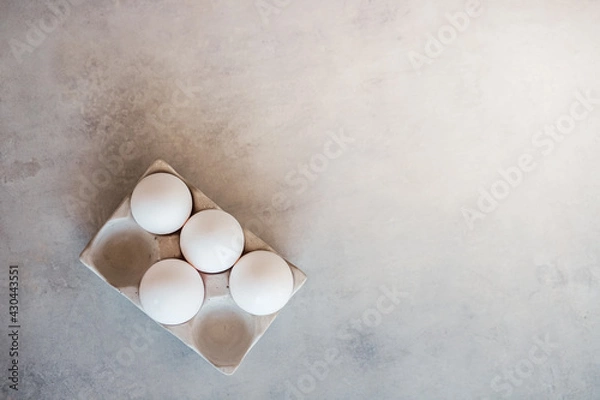 Fototapeta White eggs in a stand are on a gray concrete table. Cooking, food, ingredients
