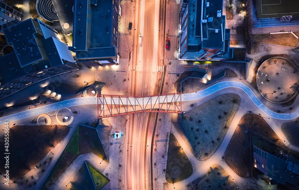 Fototapeta Aerial view of the modern neighborhood Jatkasaari of Helsinki, Finland. Modern Nordic architecture. Orange modern bicycle-pedestrian bridge over the street.