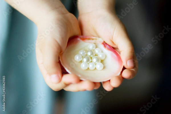 Obraz Children's hands hold oyster shell with pearls	