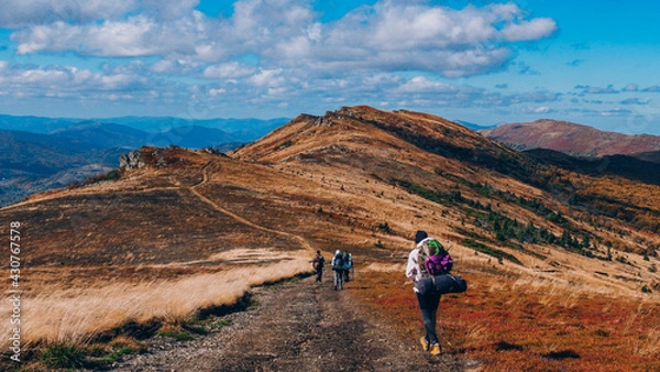 Obraz Group of People Hiking Autumn Mountain Trail Path under the clouds