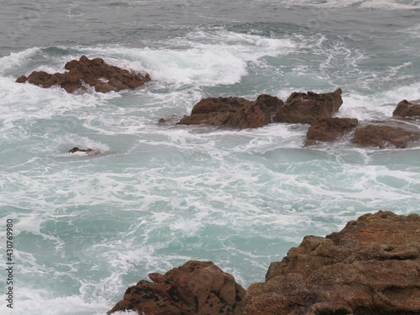 Fototapeta watching the waves playing with the rocks
