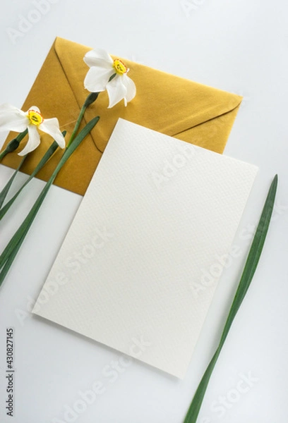 Obraz Mockup card with gold envelope and daffodils, flat lay stationery