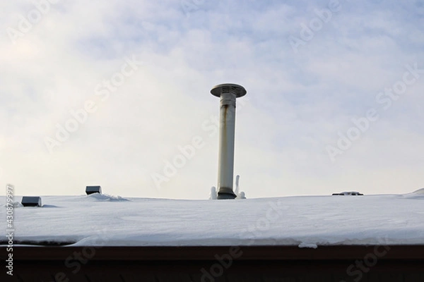 Fototapeta Frozen icicles beside a chimney stack in winter