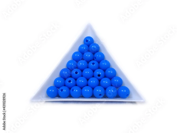 Fototapeta Photo background of round acrylic colored beads in white triangular packages on a white background