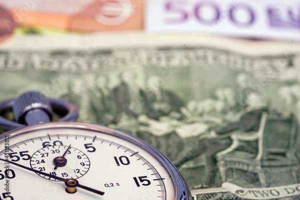 Fototapeta Money macro shot. The stopwatch lies in the center of the banknote layer. Clock. Time is money                                                              