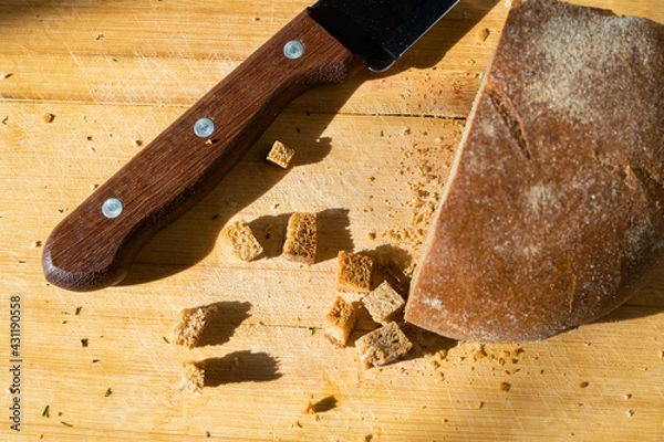 Fototapeta Wooden knife handle and sliced bread on the table