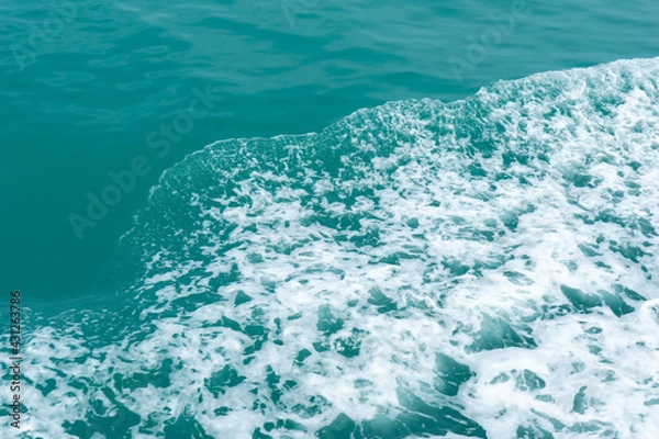 Fototapeta Trail on the water from the boat, sea waves bubble foam from boat. Stock photo image of ocean waves and sea foam caused by the sail of a speed boat, water surface behind of fast moving motor boat