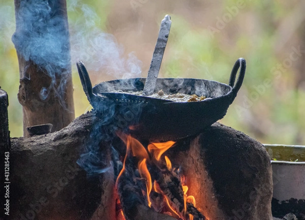 Fototapeta food cooking in a traditional indian culinary utensils kadhai on a choolah