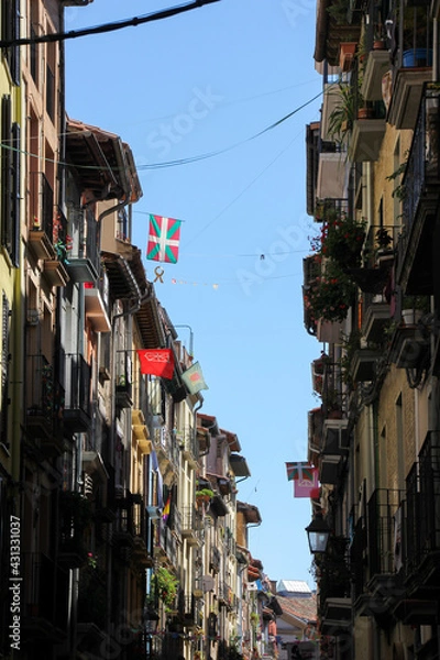 Fototapeta Pamplona street with balconies, shadows and some Basque flag
