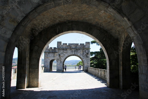 Fototapeta Porch with shade and in the background a part of the wall of Pamplona with sun