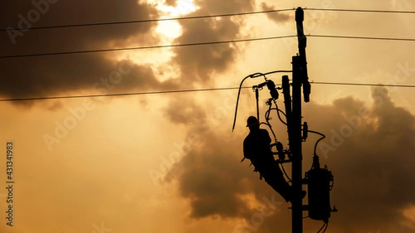 Fototapeta The silhouette of power lineman climbing on an electric pole with a transformer installed. And replacing the damaged hotline clamp, bail clamp, dropout and surge arrester that causes a power failure.
