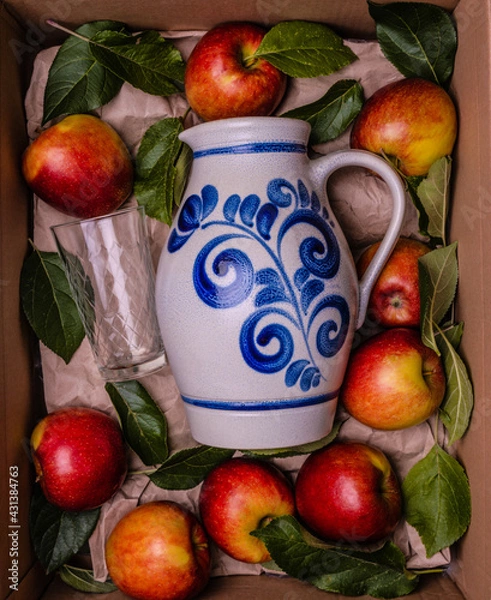 Obraz bembel with a glass and apples gift box concept