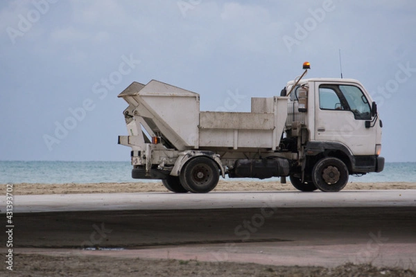 Obraz small beach maintenance truck performing cleaning tasks